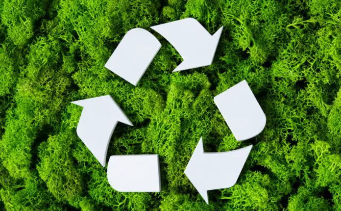 Top view of white recycle eco symbol on green moss with copy spa
